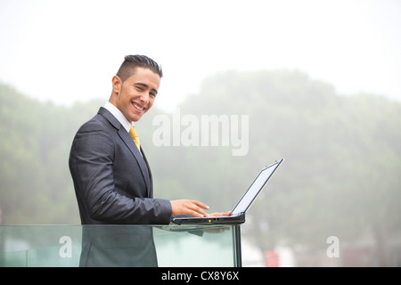 Certain jeune homme d'affaires travaillant avec son portable au bureau balcon Banque D'Images