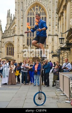 Artiste de rue sur la jonglerie monocycle à l'extérieur de l'abbaye de Bath et le local pompe à Bath Somerset England UK Banque D'Images