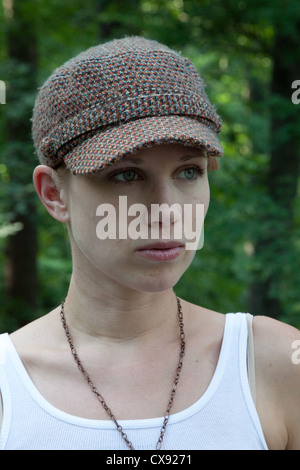 Jolie jeune femme en extérieur dans un débardeur et un joli chapeau, à gauche avec une expression grave Banque D'Images