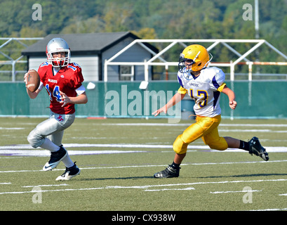 Un jeune quarterback prêt à faire une passe à un joueur se précipitant pour attaquer. Banque D'Images