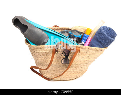 Panier en osier avec serviette, lunettes, tuba, palmes et lait solaire Banque D'Images