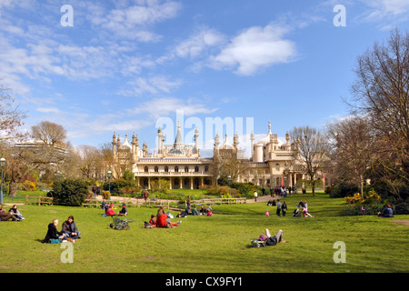 Les touristes sur l'herbe profitant d'une journée de printemps en face du quartier historique de Brighton Pavilion. Banque D'Images