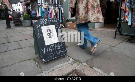 Femme marche passé Pop-Up Shop affiche à l'extérieur de magasin de vêtements vintage Flask Walk Hampstead Village London Angleterre KATHY DEWITT Banque D'Images