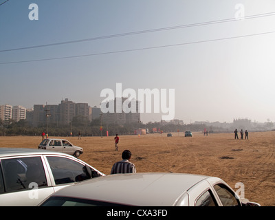 Près d'un parking vide avec fond de bâtiments et certaines personnes à Surajkund Mela dans l'Haryana, Inde. Certaines personnes à pied. Banque D'Images