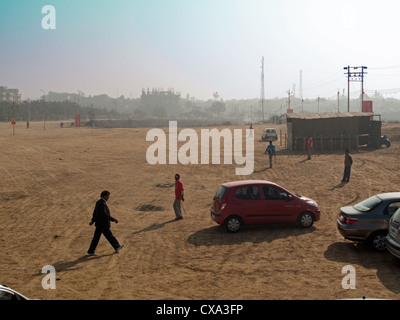 Près d'un parking vide avec fond de bâtiments et certaines personnes à Surajkund Mela dans l'Haryana, Inde. Certaines personnes à pied. Banque D'Images