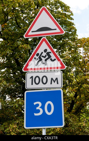 Panneau routier indiquant enfants traversant et ralentisseur Banque D'Images