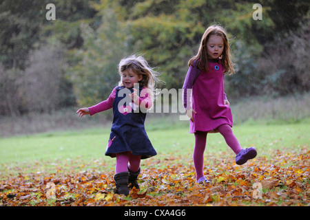 Deux jeunes filles marche à travers les feuilles d'automne sur les collines de Hubbard. Banque D'Images