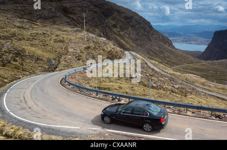 Une voiture descendant la route sinueuse qui mène Bealach na Ba, les Highlands écossais. Banque D'Images