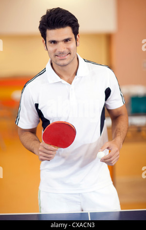 Hispanic man playing ping pong Banque D'Images