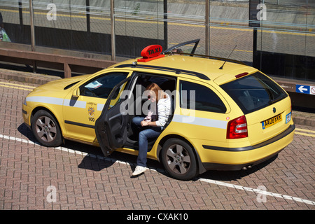 Femme en train de sortir de taxi jaune à la gare routière, routière et ferroviaire de Bournemouth, Dorset UK en septembre Banque D'Images