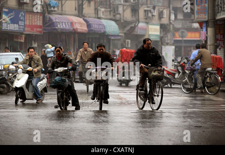 Shanghai, les cyclistes sur route mouillée Banque D'Images