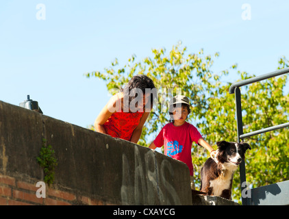 La mère et le Fils avec Collie Dog Peering Over un contre-mur en Bateau de tourisme sur Garonne Toulouse Midi-Pyrénées France Banque D'Images