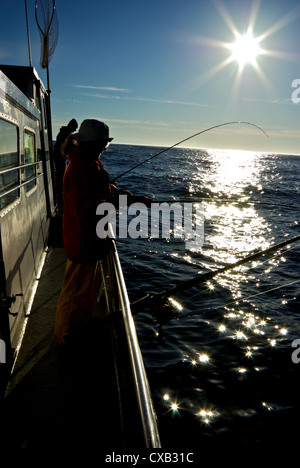 Les pêcheurs à sillhouetted contre soleil du matin ouverte à la turlutte de dérive de l'Océan Pacifique BC Ucluelet Banque D'Images