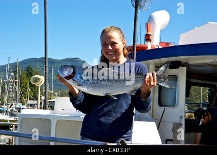 Matelot femme tenant du saumon quinnat sauvage capturé à la turlutte de dérive de l'océan Pacifique open BC Ucluelet Banque D'Images