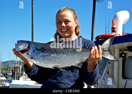 Matelot femme tenant du saumon quinnat sauvage capturé à la turlutte de dérive de l'océan Pacifique open BC Ucluelet Banque D'Images