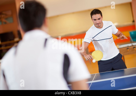 Hommes hispaniques jouant au ping-pong Banque D'Images