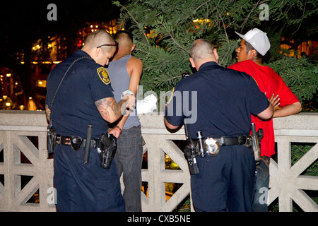 La police arrête des suspects le long de la rivière à pied à San Antonio, Texas, USA. Banque D'Images