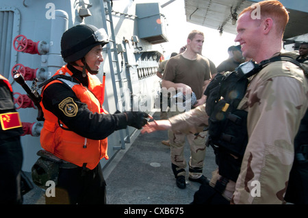 Un membre de l'équipe des Forces spéciales US à bord du destroyer lance-missiles USS Winston S. Churchill, serre la main avec un membre des forces spéciales de l'Armée de libération du peuple chinois une frégate canadienne Yi Yang à la suite d'un accord bilatéral de l'exercice de lutte contre la piraterie. L'objectif de l'exercice était américain et chinois de la coopération navale dans la détection, l'embarquement, et la recherche des navires pirates présumés. Banque D'Images