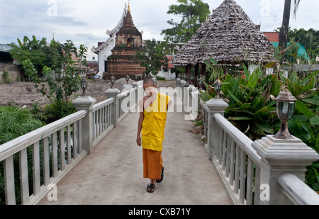 Novice en marchant le long du pont à Wat Chet Lin temple Chiang Mai Thaïlande Banque D'Images