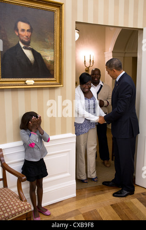 Huit ans de l'enfant réunion Janiya Penny réagit après le président américain Barack Obama qu'il se félicite de sa famille le 8 août 2012 pour le bureau ovale à la Maison Blanche. Banque D'Images