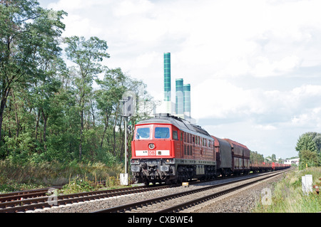 Train de fret passant une centrale électrique au gaz Banque D'Images