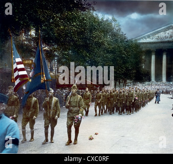 Photo colorisée des soldats américains marchant sur la place de la Madeleine lors d'un défilé de la Journée de l'armistice, Paris, France, le 11 novembre 1918. Certains soldats tiennent des fleurs. (Photo de Burton Holmes) Banque D'Images