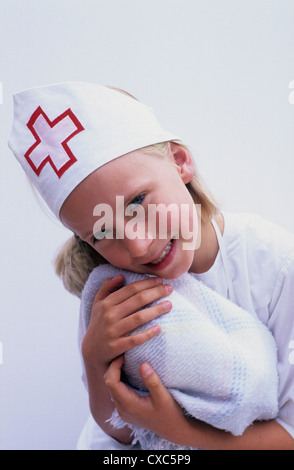 Jeune fille en costume avec les infirmières une poupée. Banque D'Images