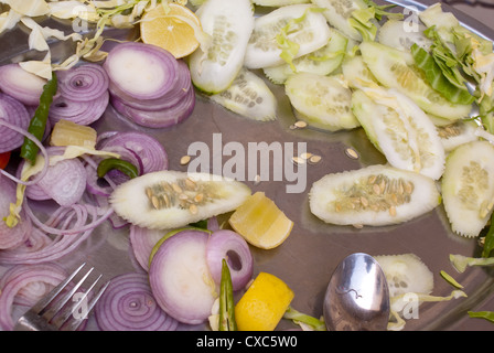 Restes d'une salade après un repas copieux, avec juste quelques morceaux de légumes à gauche. C'était à l'origine une assiette pleine de salade Banque D'Images