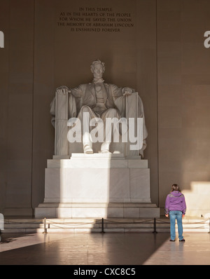 La statue de Lincoln dans le Lincoln Memorial être admiré par une jeune fille, Washington D.C., États-Unis d'Amérique Banque D'Images