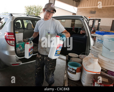 Employé à la ville de Austin de décharge de déchets ménagers dangereux de la peinture pour éliminer correctement les résidents Banque D'Images