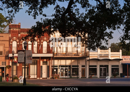 Boutiques en place du palais de justice, vu par les succursales de Hanging Tree live oak, Goliad, Texas, États-Unis Banque D'Images