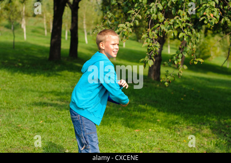 Petit Garçon jouant sur l'herbe verte de frisbee Banque D'Images