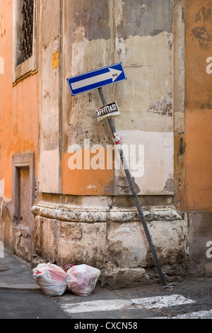 Détails du mur, deux sacs poubelles de détritus et d'une façon tordue d'un panneau routier dans les rues de Rome, Roma, Italie, Italia, Europe Banque D'Images