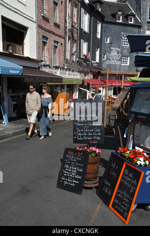 Attractive young couple walking passé seafood restaurant menus tableau noir sur quai Deauville Normandie France Banque D'Images