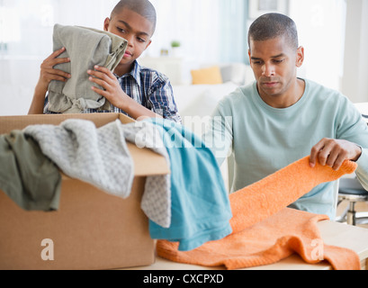 Père et fils folding clothes for Charity Banque D'Images