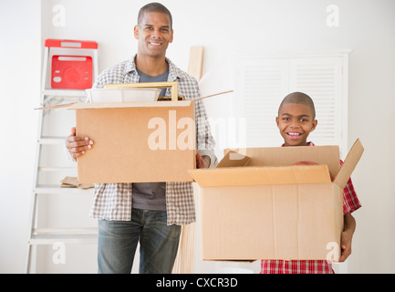 Père et fils holding moving boxes Banque D'Images