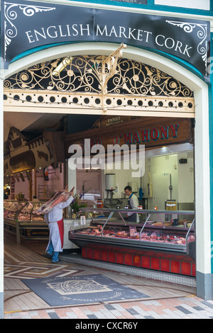 Un boucher avec un agneau entier par-dessus son épaule le marché anglais, la ville de Cork, République d'Irlande. Banque D'Images