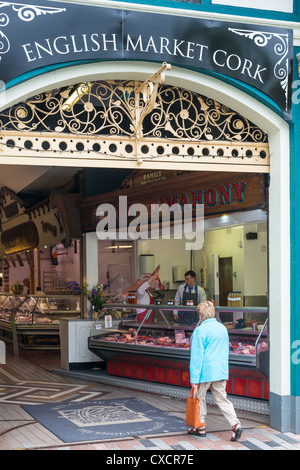 Un boucher avec son ensemble par-dessus son épaule le marché anglais, la ville de Cork, République d'Irlande. Banque D'Images