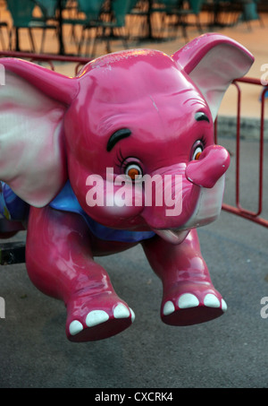 C'est une photo d'un éléphant rose d'un carrousel ou merry-go-round dans un parc. Il n'y a personne Banque D'Images