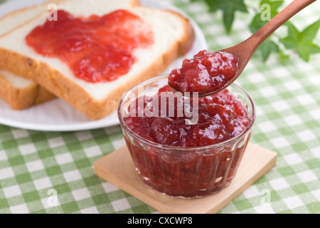 L'écopage confiture de fraise avec cuillère Banque D'Images