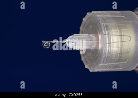 Macro extrême d'une goutte d'insuline sur une aiguille hypodermique Banque D'Images