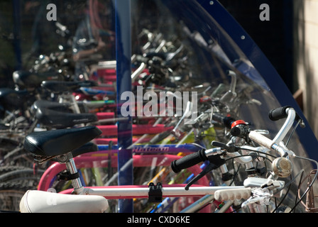 Les vélos garés infiltration en toute sécurité dans une aire de stationnement à l'extérieur d'une gare d'Angleterre. Banque D'Images