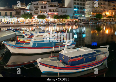 Les bateaux de pêche en bois peintes de couleurs vives sur le lac d''Agios Nikolaos, Crète, Grèce, la nuit Banque D'Images