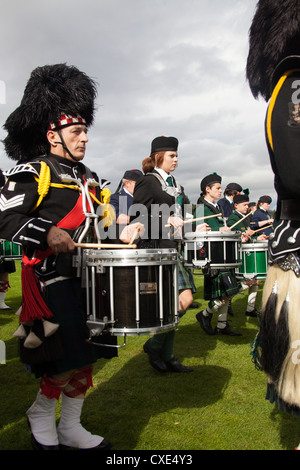 Village de Braemar, l'Écosse. Batteurs dans les corps de cornemuses défilant au Royal Braemar Gathering jeux. Banque D'Images