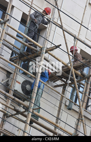 Shanghai, travailleurs de la construction sur un Bambusgeruest Banque D'Images