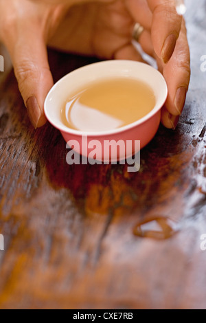 Woman's hand holding petite tasse de thé Banque D'Images