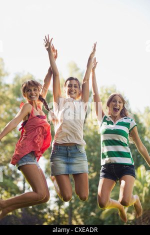 Les jeunes femmes sautant dans l'air, smiling Banque D'Images