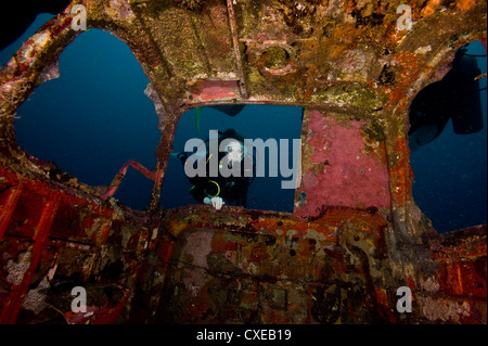 Diver entrant dans la vitre avant de la quatre places plane wreck, Philippines, Asie du Sud, Asie Banque D'Images