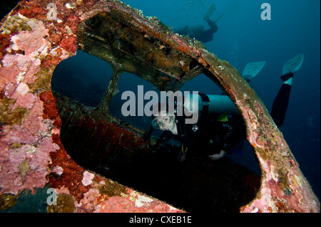 Diver entrant dans la vitre avant de la quatre places plane wreck, Philippines, Asie du Sud, Asie Banque D'Images