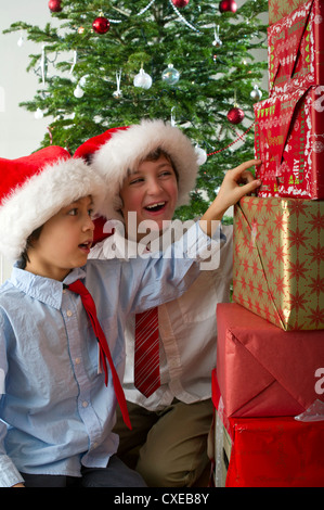 Les garçons avec excitation à la pile de cadeaux de Noël à Banque D'Images